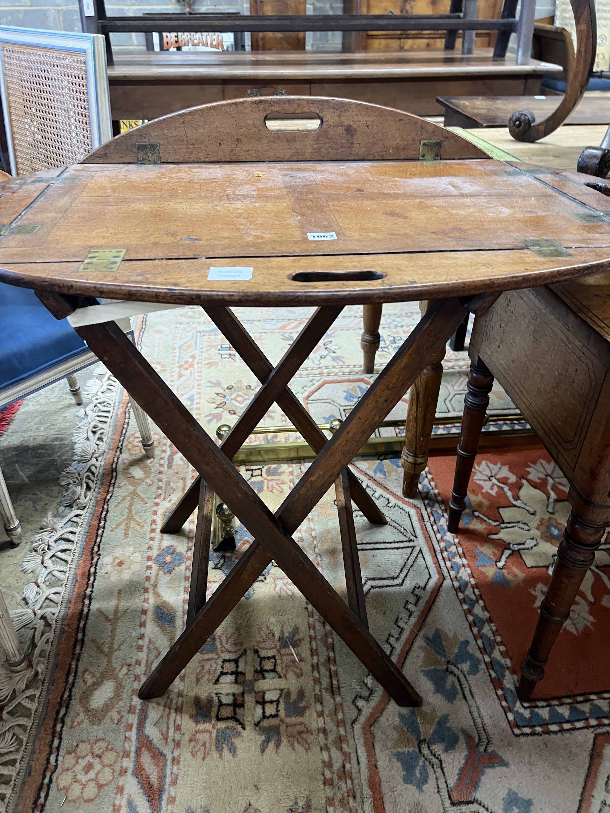 A Victorian brass mounted oval mahogany folding butler's tray / table on stand, width 90cm, height 82cm